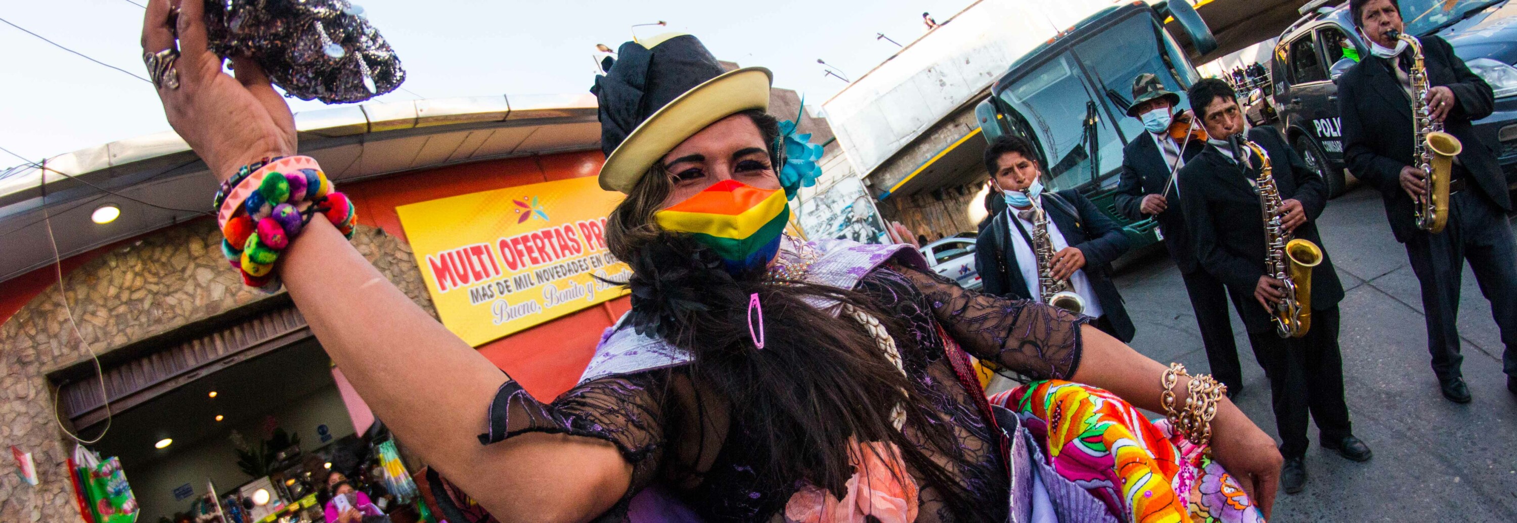 Person with Pride Mask with three musicians in the background.